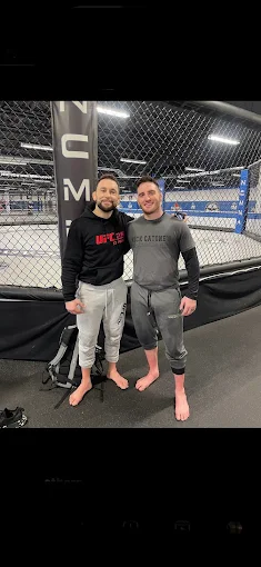 Frankie Edgar and a training partner beside the cage