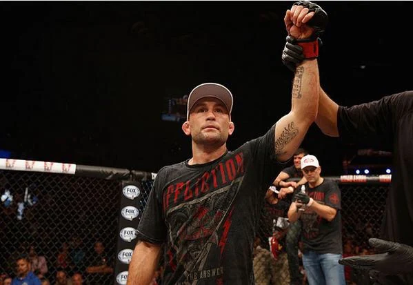 Frankie Edgar with his hand raised in the cage after a win